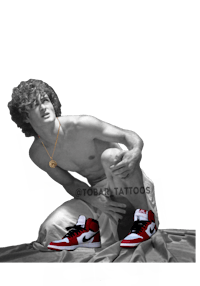 a man is kneeling on a bed with a pair of shoes on his feet