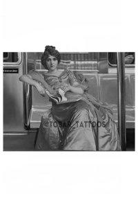 a black and white image of a woman sitting on a train